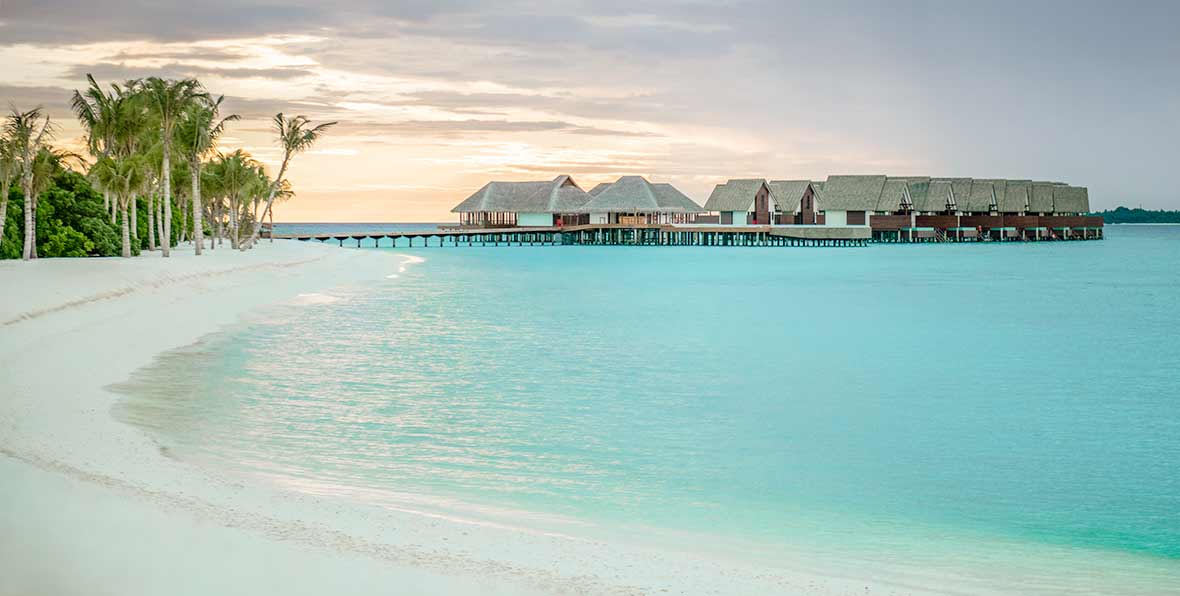 playa y villas al atardecer en Heritance Aarah Maldives