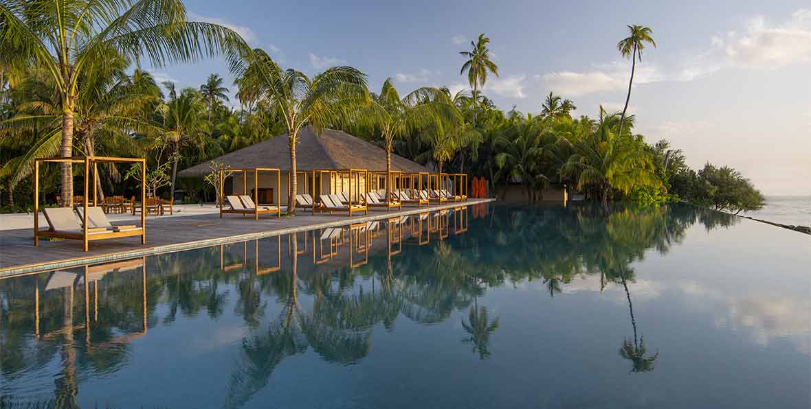 piscina y palmeras en The Residence Maldives at Dhigurah