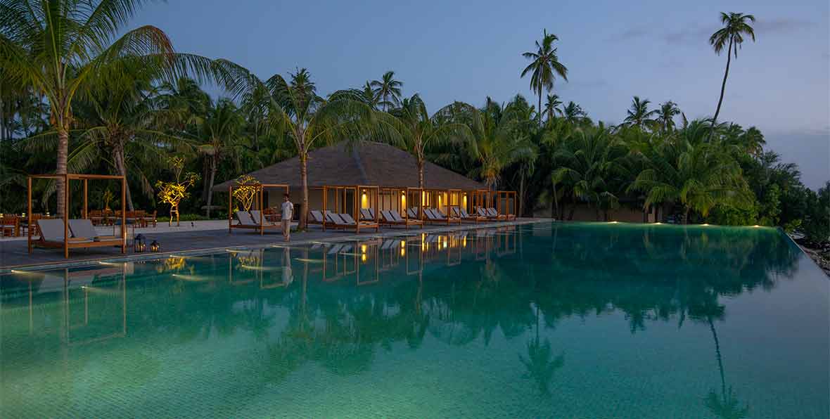 la piscina de The Residence Maldives at Dhigurah al atardecer