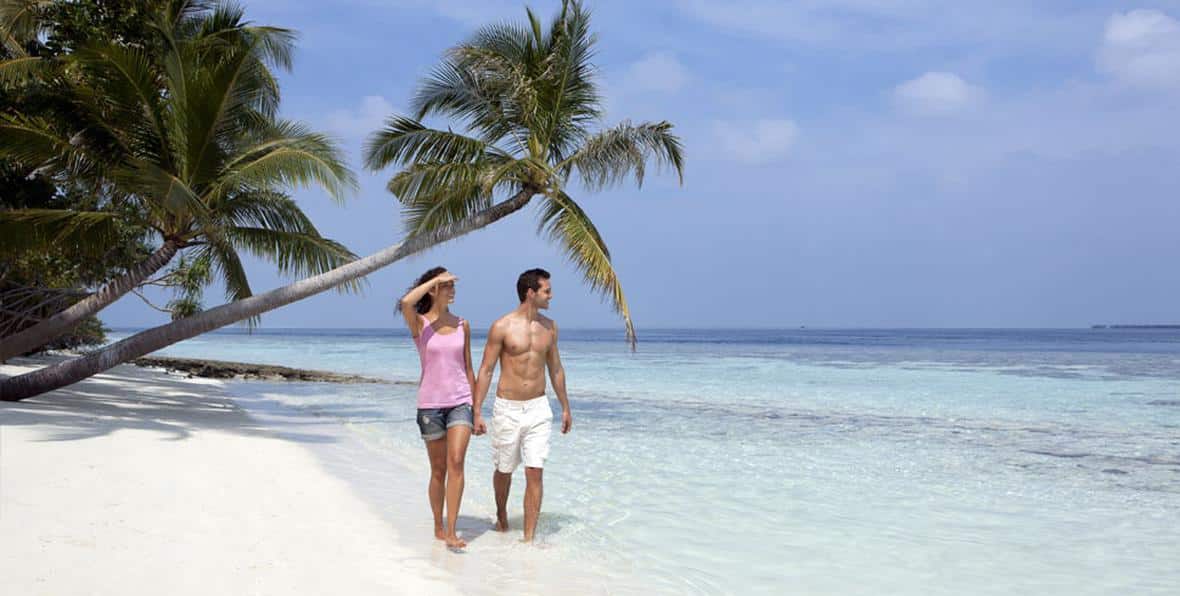 Pareja paseando en la playa del Vilamendhoo Island Resort